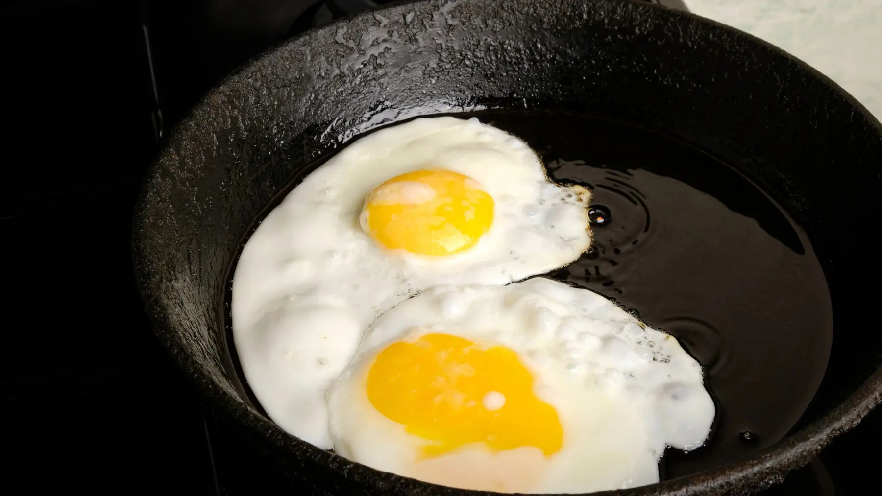 Corned Beef Hash and Eggs: A Cast Iron Campfire Breakfast 4 Fried eggs cooking in a cast iron pan
