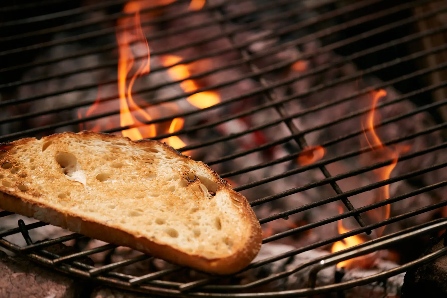 Country bread toasting on a grate over a wood fire