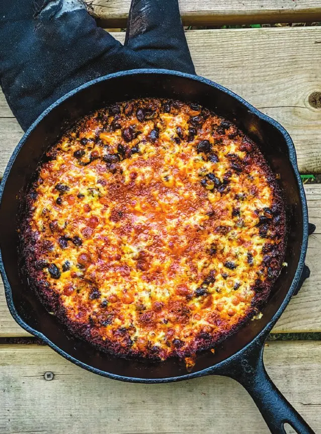 Beans au Gratin 1 Cast iron skillet of beans au gratin with torched melted cheese over a campfire
