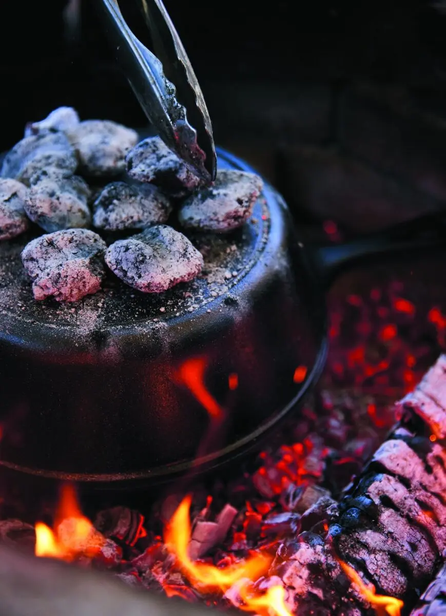 Dutch Oven Bread 2 Hot coals arranged on the lid of a cast iron dutch oven over a campfire